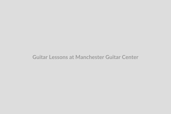 Man playing a guitar in the guitar center lesson room