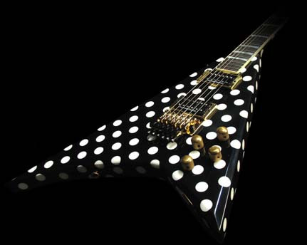 Front view of a modern Jackson Custom Shop hybrid Polka Dot and Pinstripe Flying V guitar