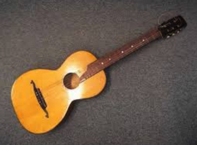 News clipping about George Harrison's first guitar being discovered and auctioned