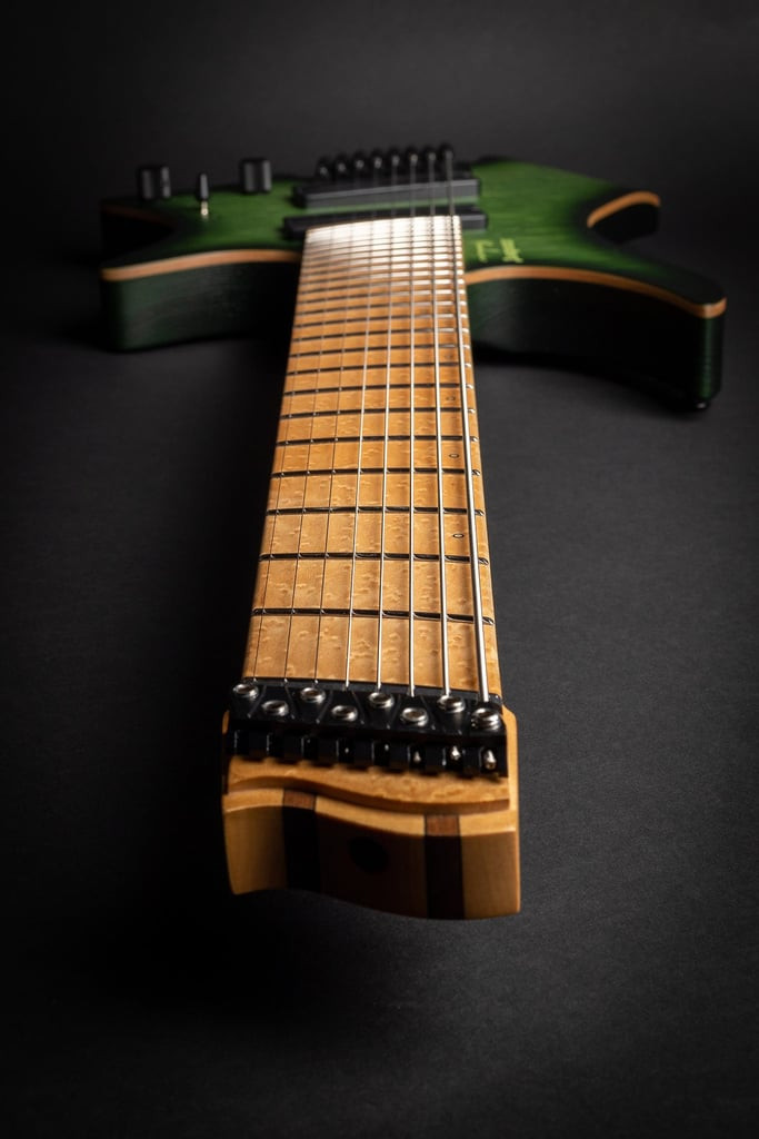 Strandberg Boden Original NX 8 string headless guitar in Earth Green, highlighting the extended fretboard and headless design optimized for ergonomic playing.