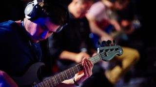 Bass guitar player testing headphones for guitar amp use