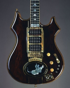 Close-up detail of the Tiger Guitar's body, showing wood layers and brass binding