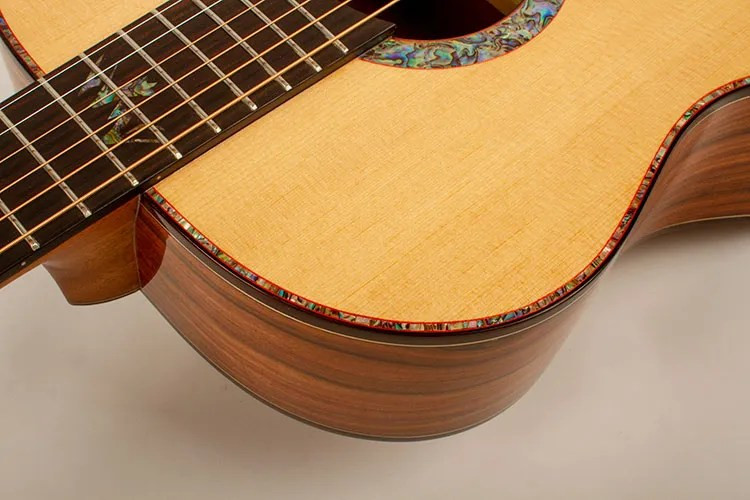 Close-up of the elegant abalone binding and purfling on the Washburn Bella Tono acoustic guitar, highlighting the detailed craftsmanship.