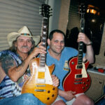 Dickey Betts showing off the prototypes on his bus, 2001, displaying the stripped and refinished redtop Les Paul, exemplifying his personalized approach to his working guitars.