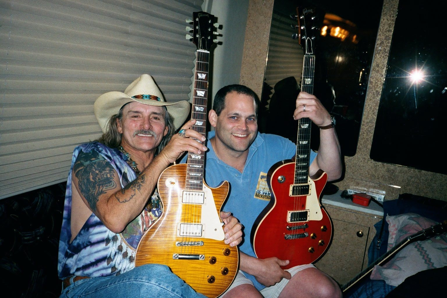 Dickey Betts showing off the prototypes on his bus, 2001, displaying the stripped and refinished redtop Les Paul, exemplifying his personalized approach to his working guitars.
