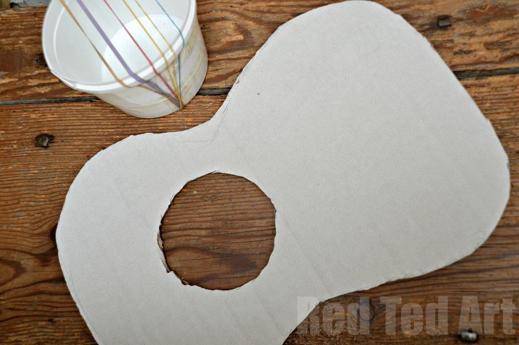 Cardboard guitar body ready for assembly, showcasing the cut-out shape and sound hole