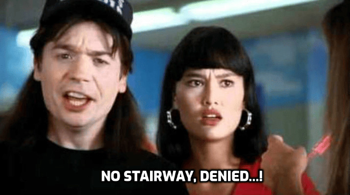 Wayne Campbell looking at the NO STAIRWAY TO HEAVEN sign in Wayne's World