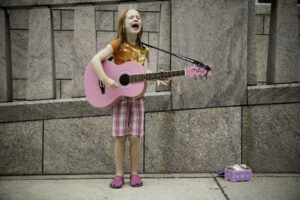 A young boy smiling while playing an electric guitar, showcasing the joy of music