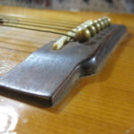 Bellied guitar top showing a bulge behind the bridge