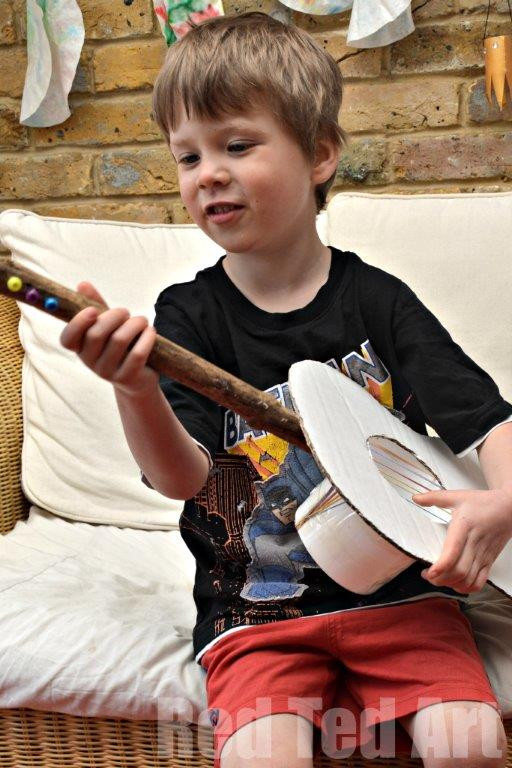 Decorated cardboard guitar with paint, stickers, and colorful designs
