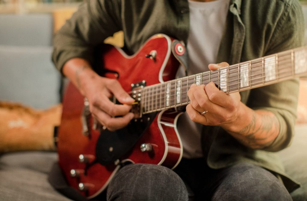 Man playing guitar with a pick