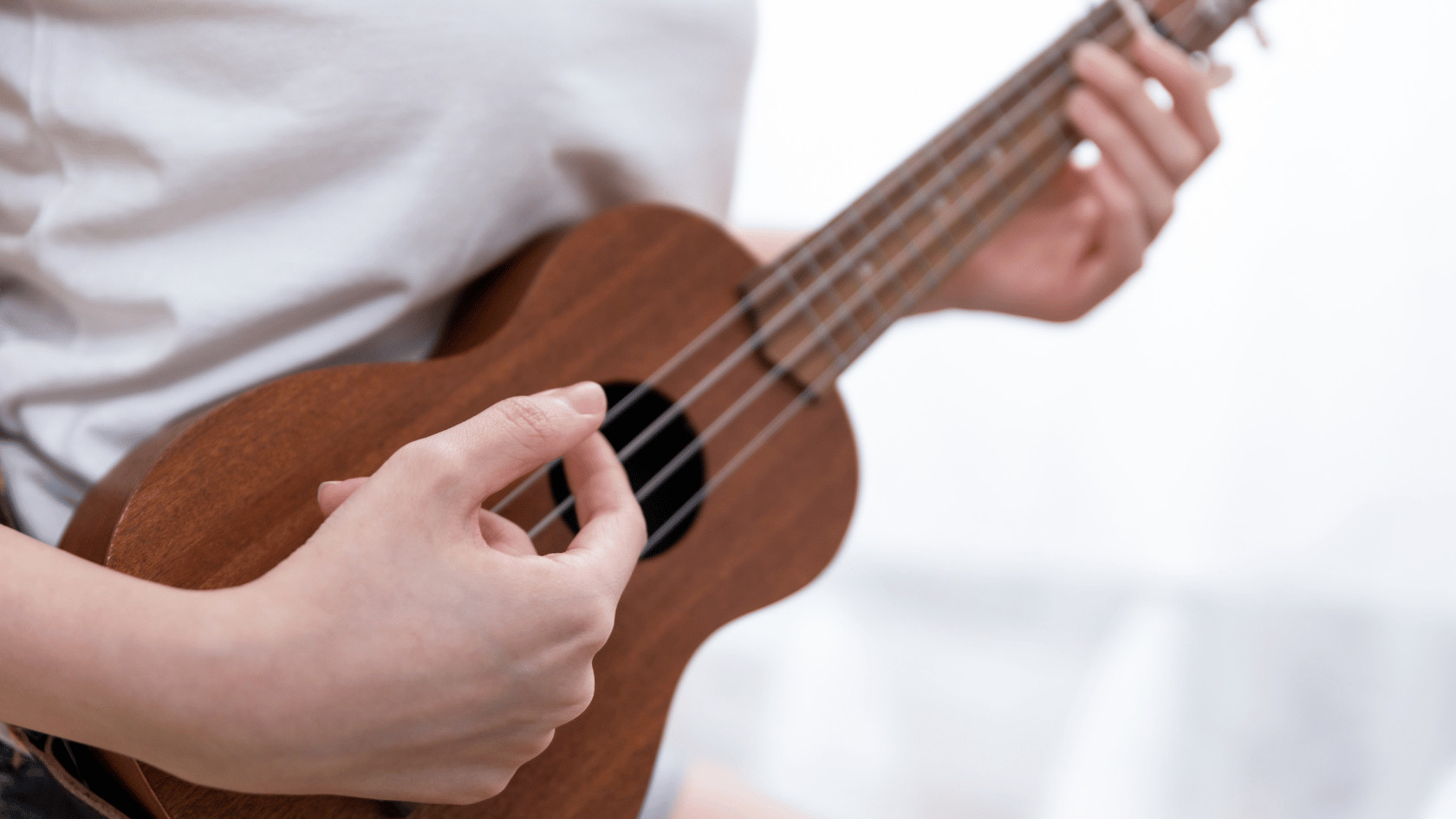 Zooey Deschanel playing ukulele, showcasing her skills as a ukulele-playing songbird
