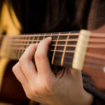 Acoustic guitar neck and fretboard showing the strings and frets