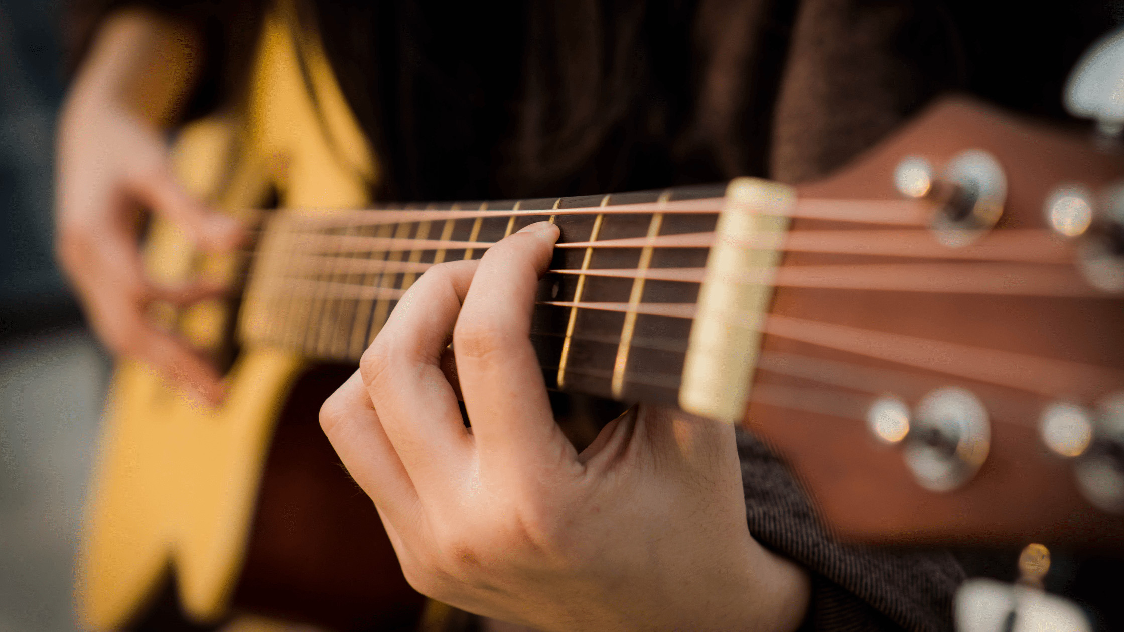 Acoustic guitar neck and fretboard showing the strings and frets