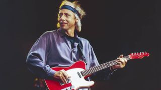 Mark Knopfler playing his guitar during a performance